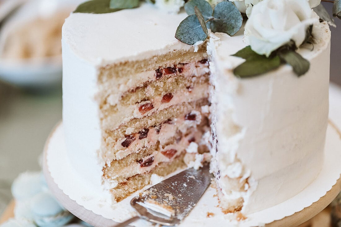 Detailaufnahme einer angeschnittenen Hochzeitstorte.