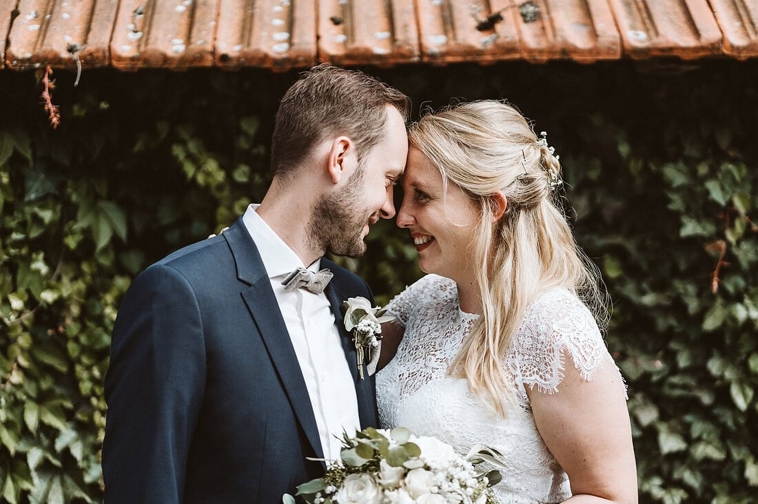 Ein Hochzeitspaar steht Stirn an Stirn auf einem Bauernhof in Bad Laer und schaut sich tief in die Augen.