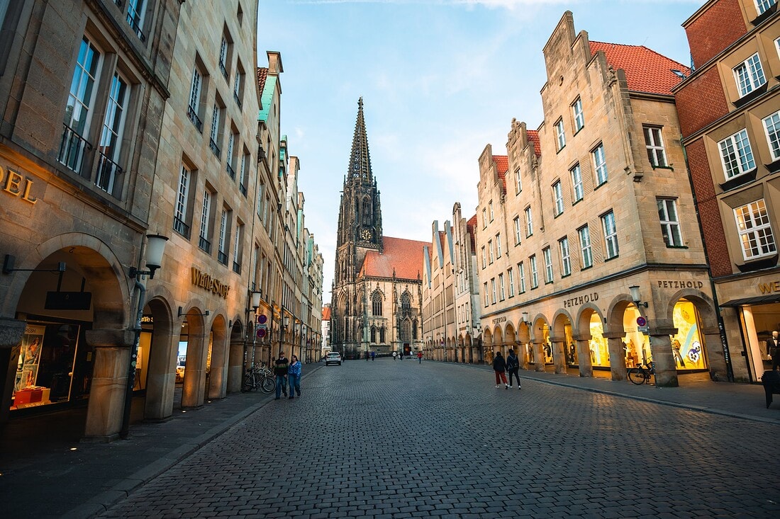 Picturesque street view in Münster, Germany showcasing a prominent Gothic church and historic buildings.
